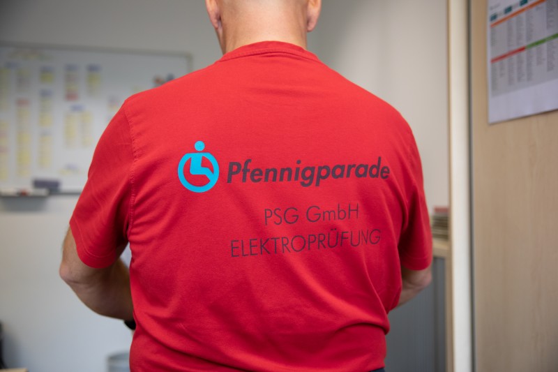Mitarbeiter der Elektroprüfung, T-Shirt mit Aufschrift: Pfennigparade PSG GmbH Elektroprüfung