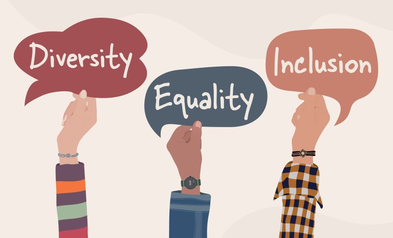Hände die Schilder "Diversity", "Equality" und "Inclusion" hochhalten